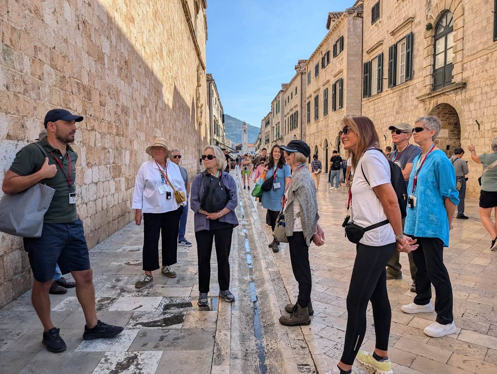 A gathering of pedestrians navigating a narrow street, showcasing a vibrant urban scene.