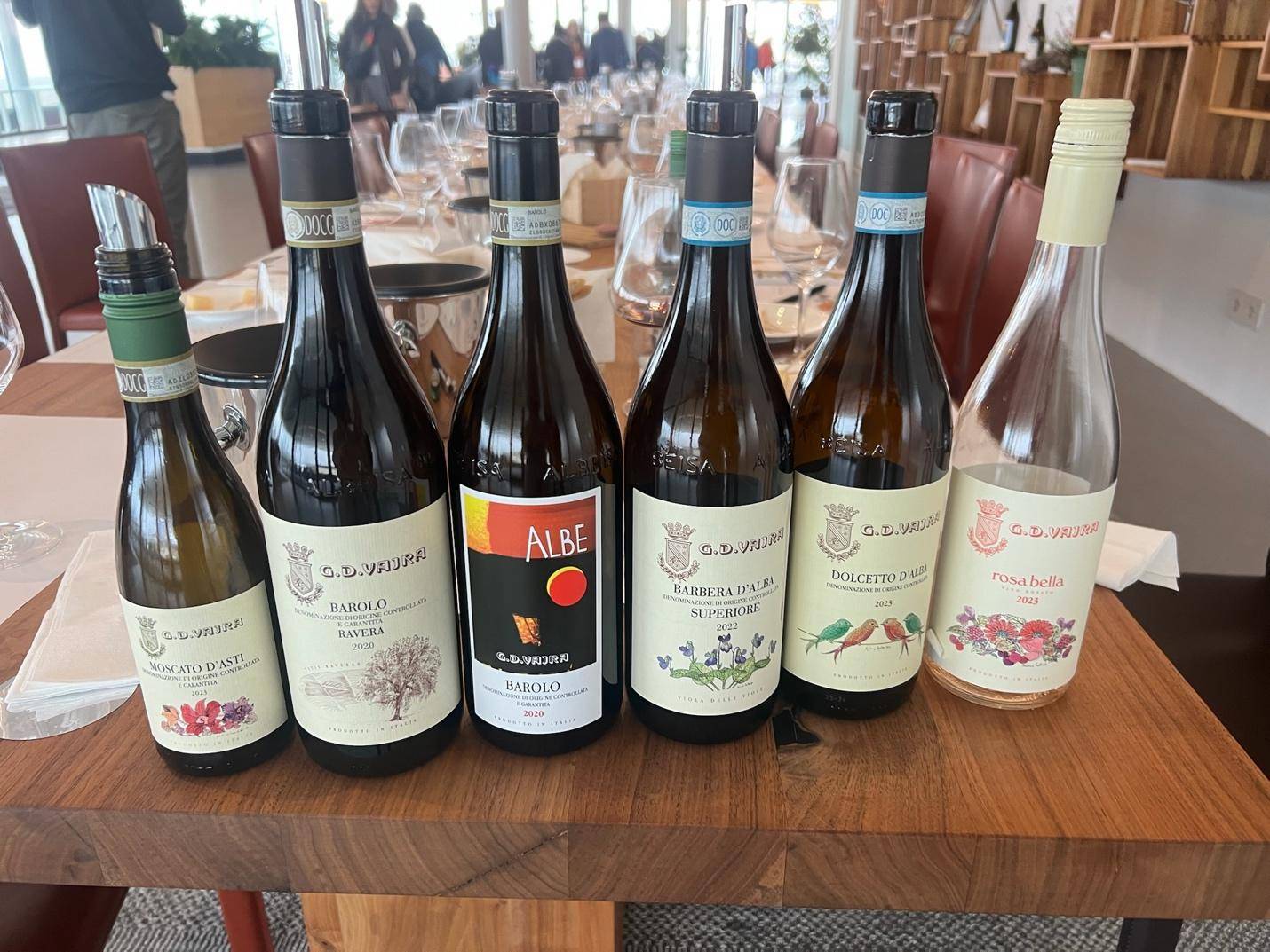 A group of people enjoying a wine tasting experience at an elegant Italian restaurant, surrounded by fine wines and cuisine.