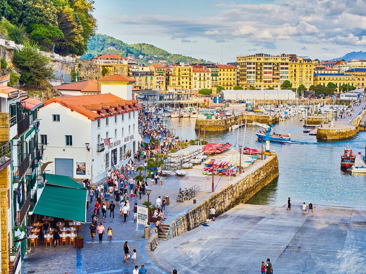 A bustling city skyline featuring numerous buildings alongside a vibrant harbor filled with boats and activity.