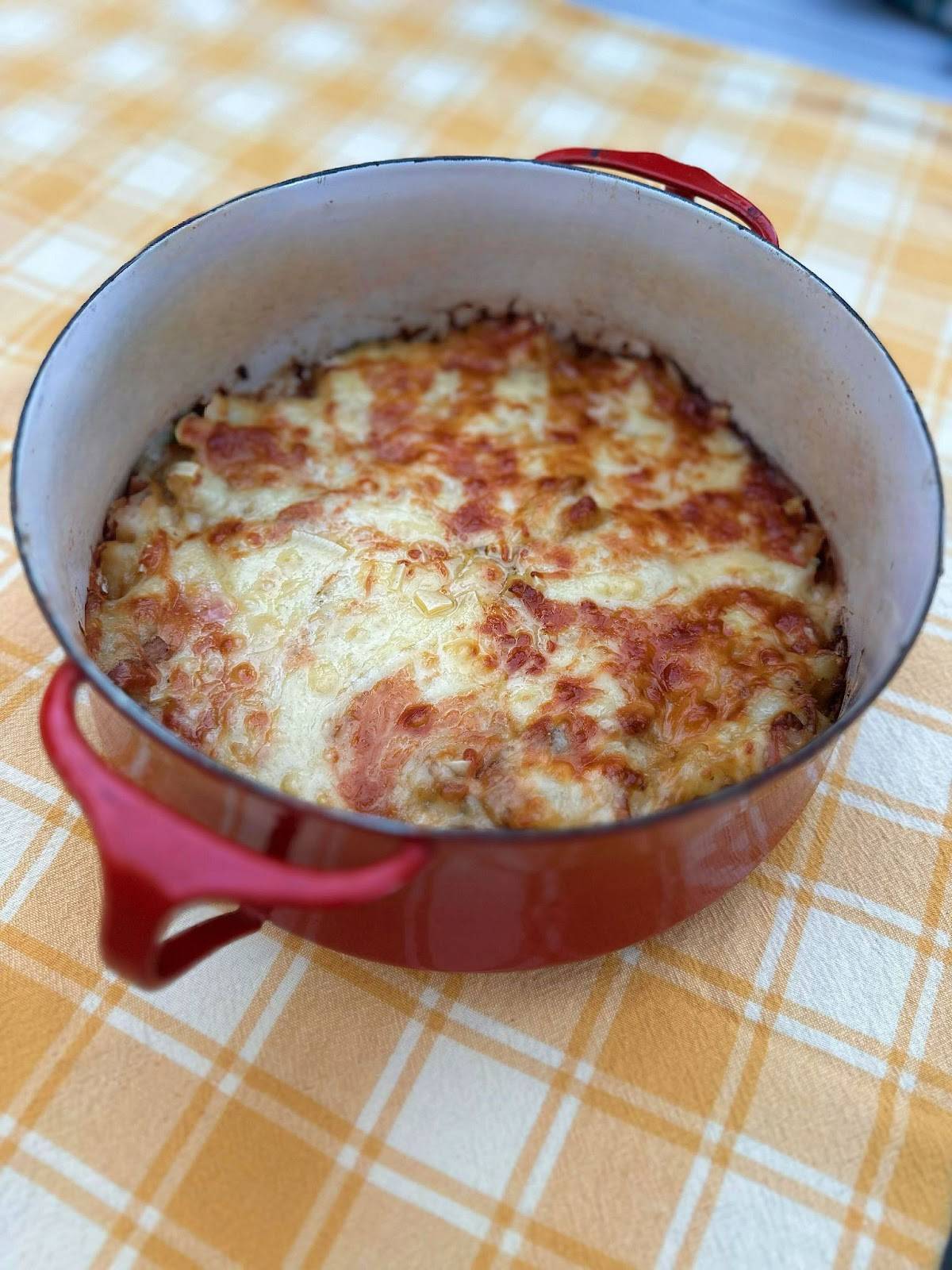 A casserole dish filled with melted cheese and rich sauce, showcasing a deliciously baked meal ready to serve.