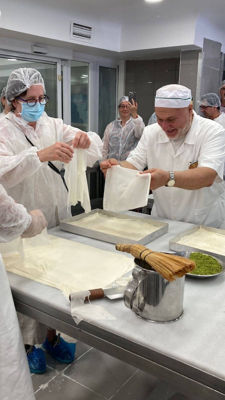 A team in white uniforms engaged in food preparation, showcasing teamwork in a culinary setting.
