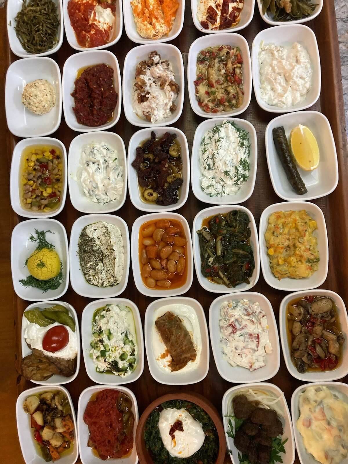 A tray displaying various foods in white bowls, showcasing a colorful assortment of dishes.