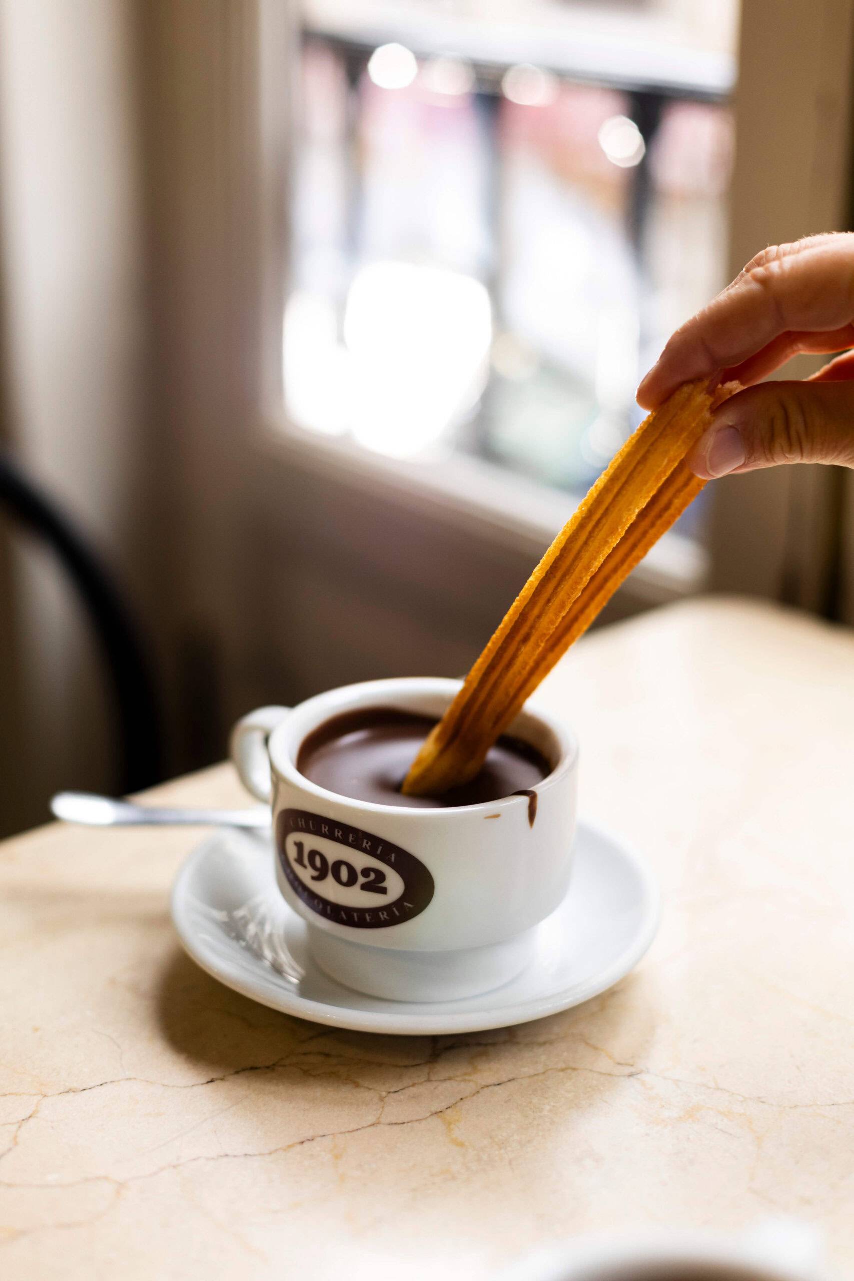 A close-up of a person holding a churro