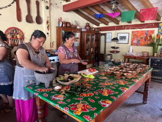 Three women collaborate in a kitchen
