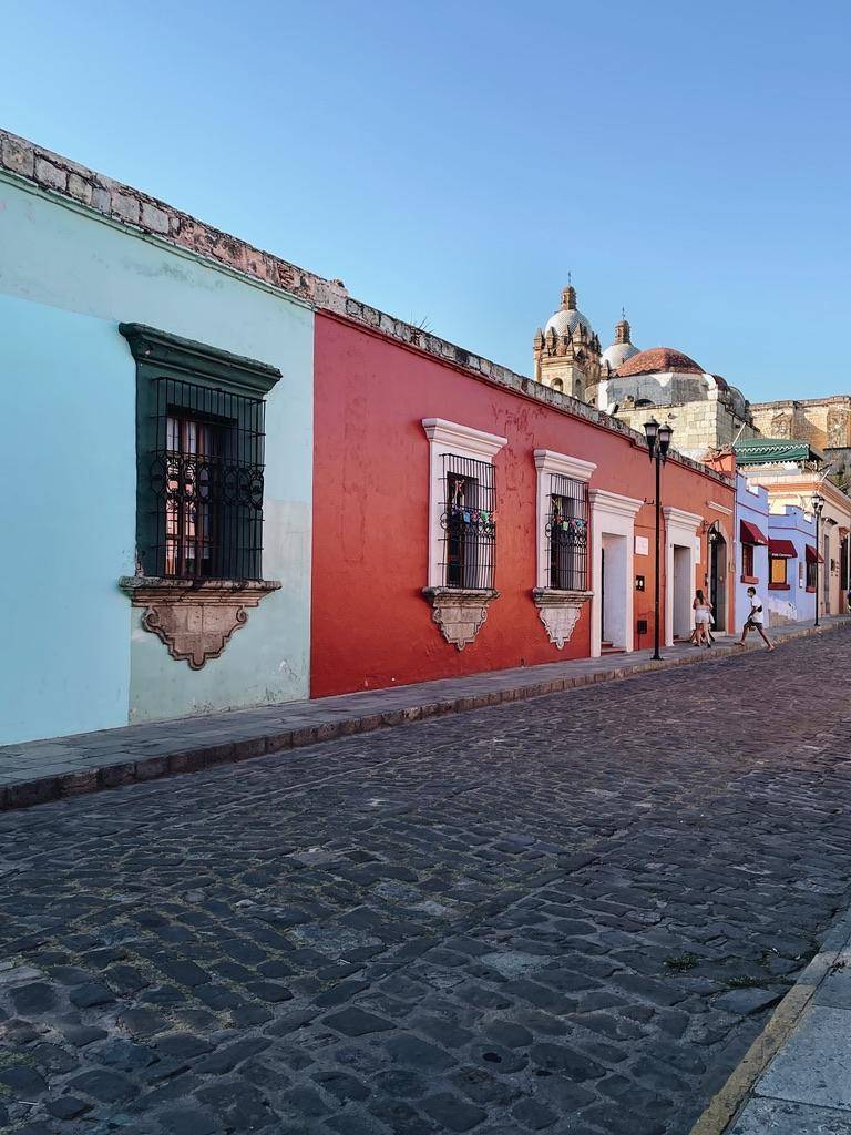Colorful buildings line cobblestone streets in a charming town, creating a vibrant and picturesque urban scene.