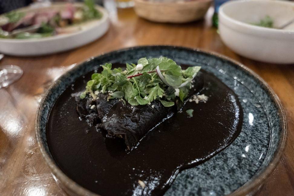 A plate of food topped with a rich black sauce, showcasing a gourmet presentation.