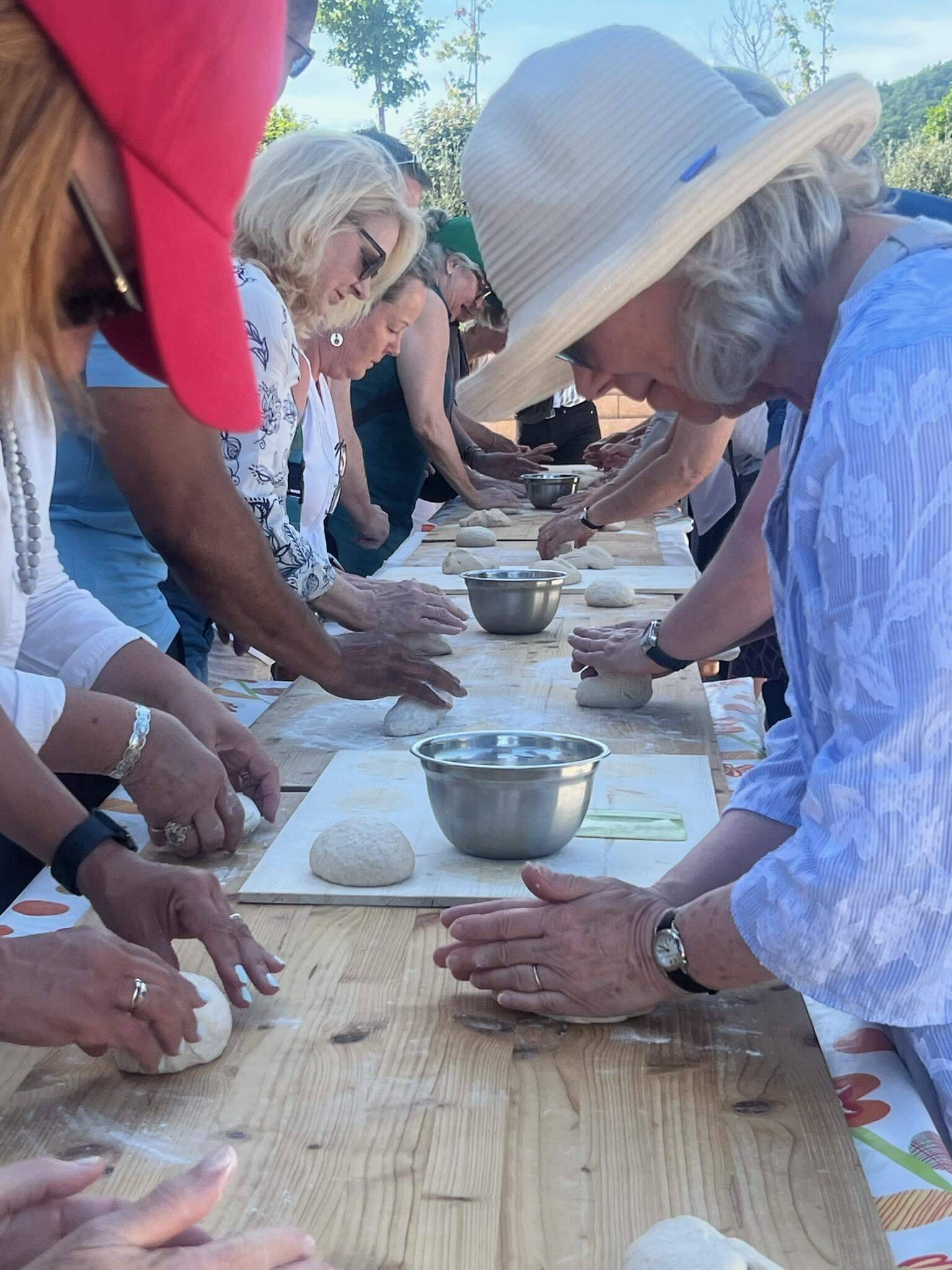 A diverse group of people engaged in making dough on a table