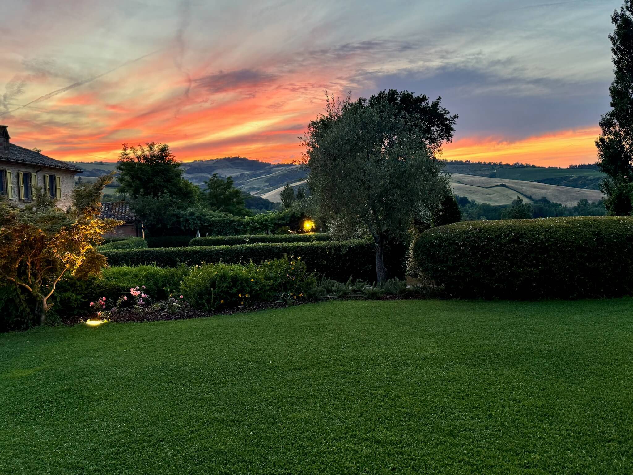 A vibrant sunset casts warm hues over a tranquil countryside