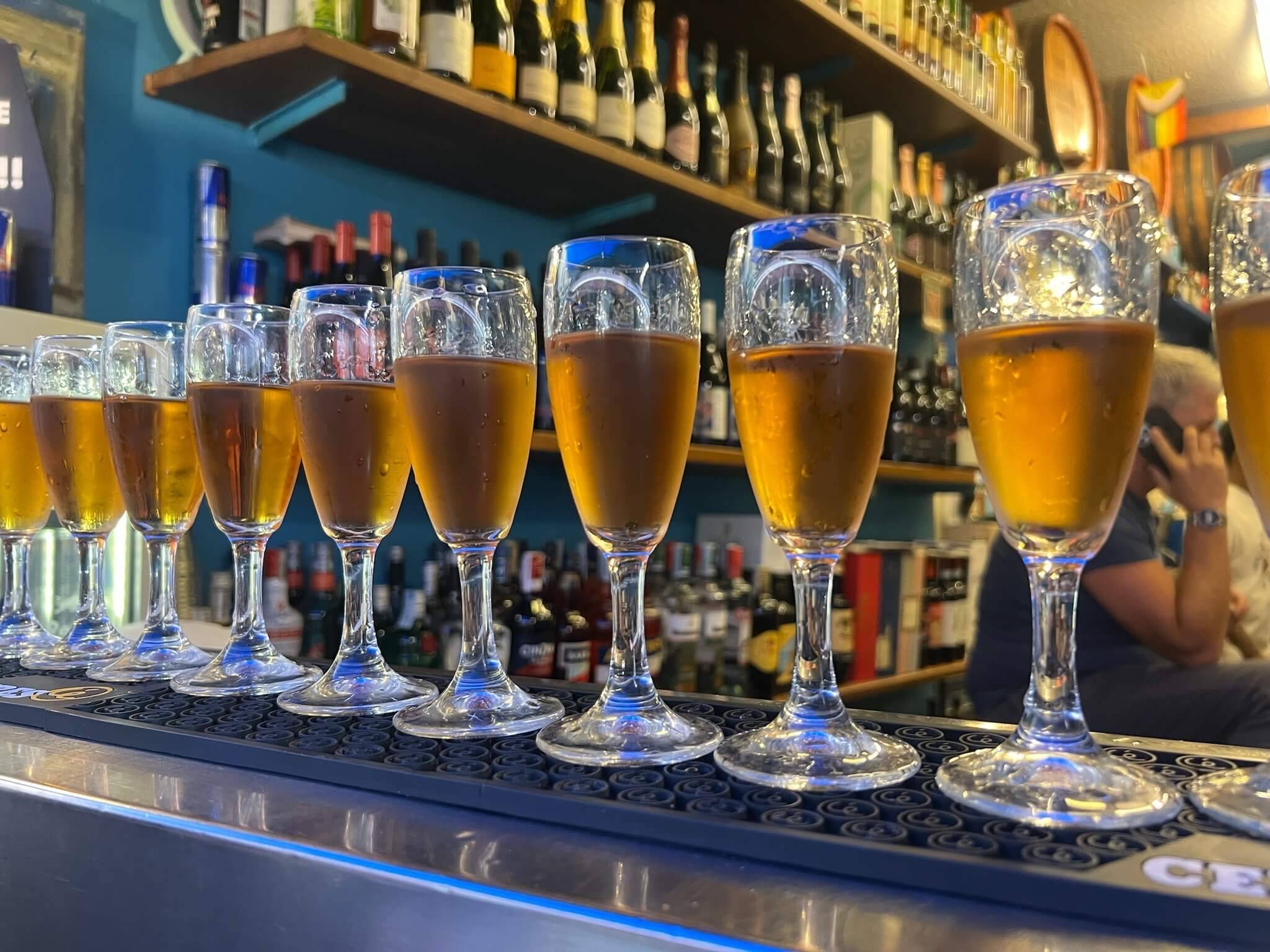 A row of glasses filled with various types of beer