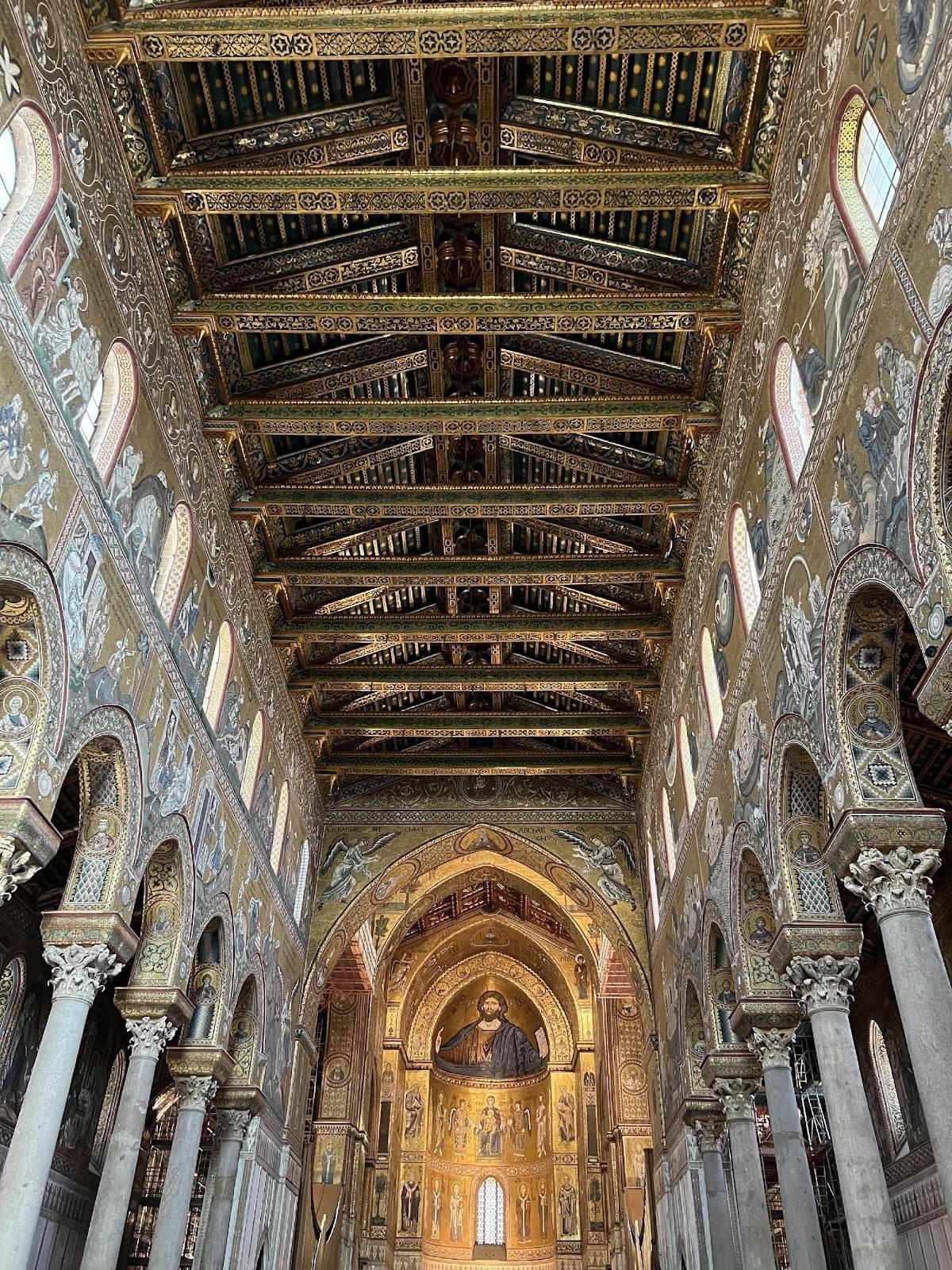 Interior view of a church showcasing intricate, ornate ceilings with detailed artwork and architectural features.