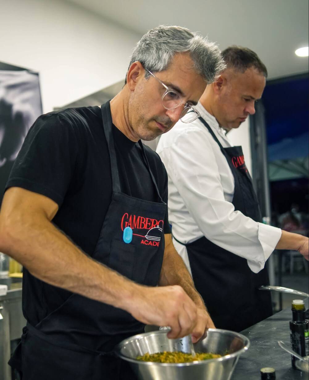 Two men in aprons are cooking together in a kitchen