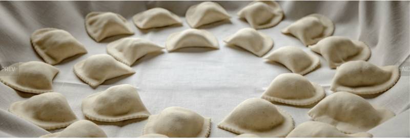 A circle of dumplings arranged neatly on a white cloth