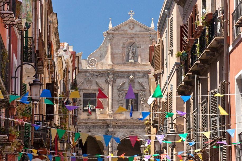 Colorful triangular flags hang across a narrow street