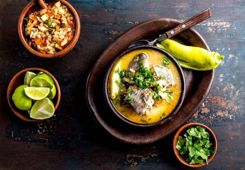 A bowl filled with fish, rice, and assorted vegetables, showcasing a colorful and nutritious meal.