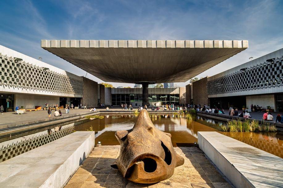 A large stone sculpture sits before a reflecting pool