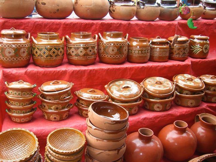 Rows of handcrafted brown clay pots and dishes