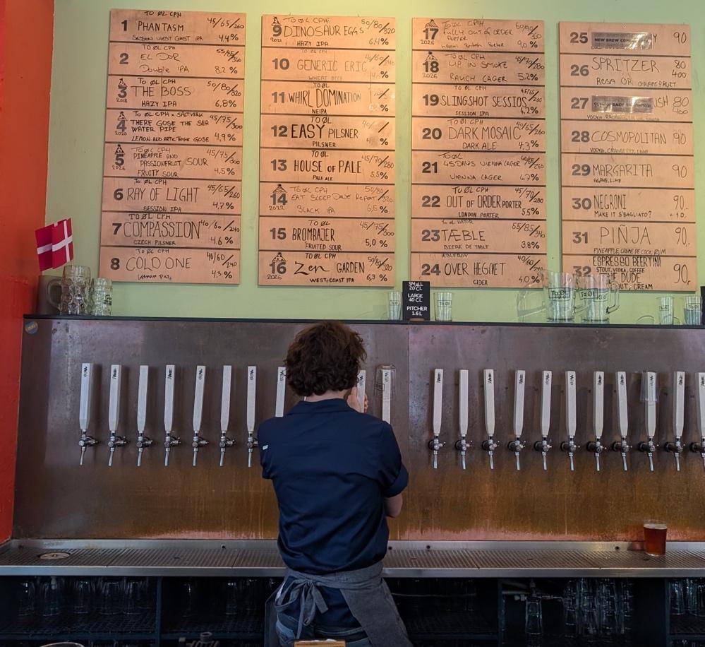 A man poses in front of a beer tap