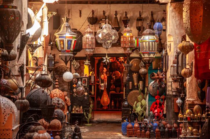 A vibrant market scene filled with various decorative lanterns and metal crafts, showcasing intricate designs and colors.